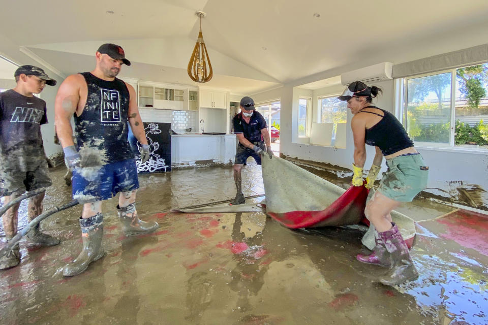 Glenn family members clean up their flood-damaged house from Cyclone Gabrielle in Napier, New Zealand, Monday, Feb. 20, 2023. Cyclone Gabrielle struck the country's north on Feb. 13 and the level of damage has been compared to Cyclone Bola in 1988. That storm was the most destructive on record to hit the nation of 5 million people. (Warren Buckland/Hawkes Bay Today via AP)