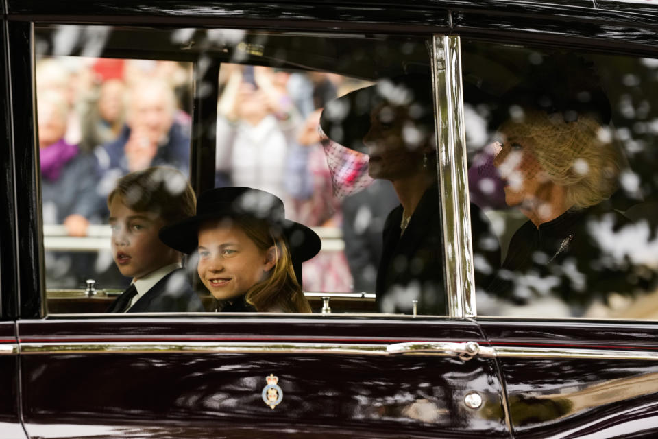 Britain's Prince George, Prince Charlotte, Kate, Princess of Wales and Camilla, the Queen Consort, from left, arrive by car ahead of the Queen Elizabeth II funeral in central London, Monday, Sept. 19, 2022. The Queen, who died aged 96 on Sept. 8, will be buried at Windsor alongside her late husband, Prince Philip, who died last year. (AP Photo/Andreea Alexandru, Pool)
