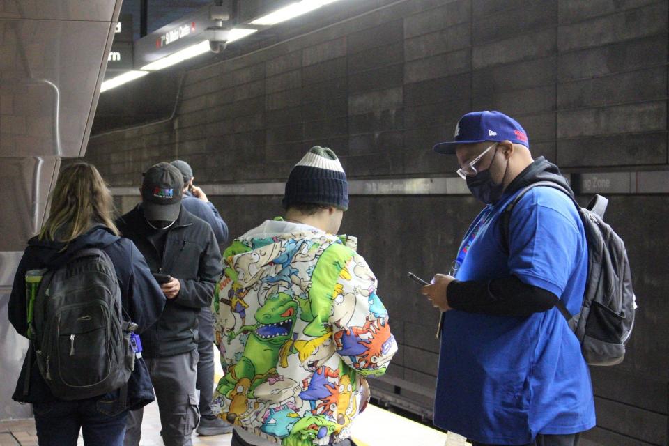 Mark Lewis, right, of People Assisting the Homeless (PATH) speaks to an unhoused person at a Metro station stop in downtown Los Angeles.