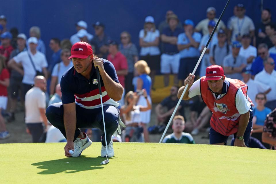 Oct 1, 2023; Rome, ITA; Team USA golfer Brooks Koepka lines up his putt with his caddie Ricky Elliott on the seventh green during the final day of the 44th Ryder Cup golf competition at Marco Simone Golf and Country Club. Mandatory Credit: Kyle Terada-USA TODAY Sports