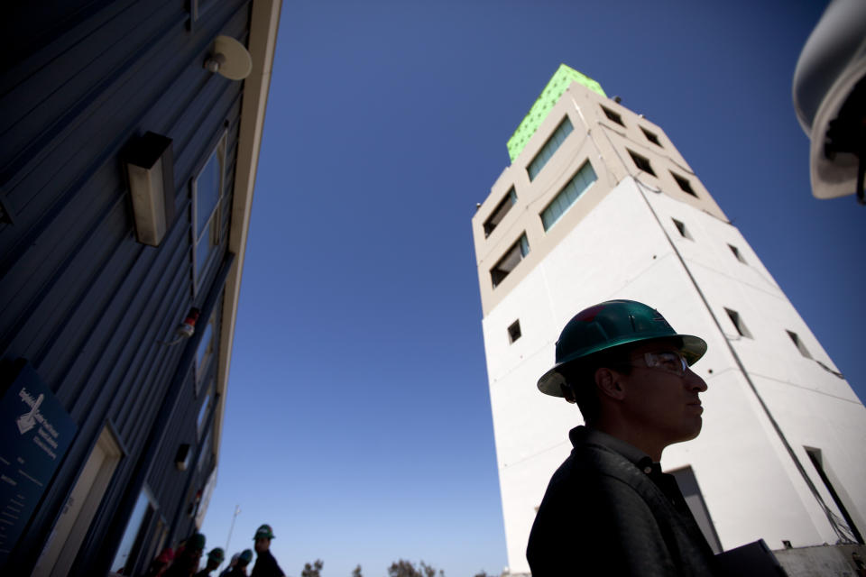 Elias Espino, an engineering student at San Diego State University, talks in front of a five-story building constructed to study earthquakes at a facility run by the University of California at San Diego Tuesday, April 17, 2012, in San Diego. To study the affects of earthquakes, researchers will repeatedly shake a building over a span of two weeks as part of the $5 million experiment funded by government agencies, foundations and others. (AP Photo/Gregory Bull)