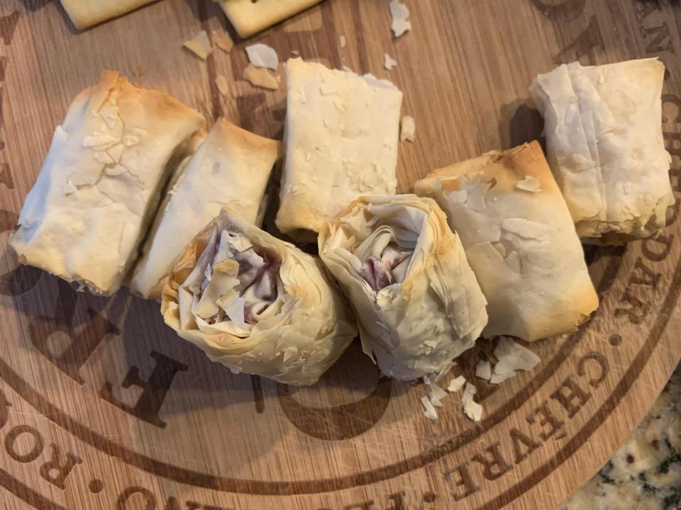 cooked trader joes cheese and cranberry bites on wooden cutting board