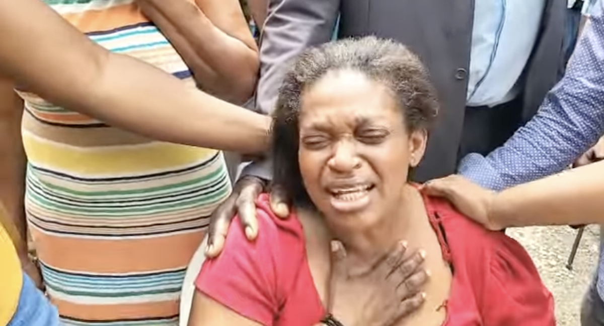 Gwendolyn McKnight es consolada mientras llora el asesinato de su hija y sus cuatro nietos cerca de Kingston, Jamaica, el martes 21 de junio de 2022  (Jamaica Observer newscast)