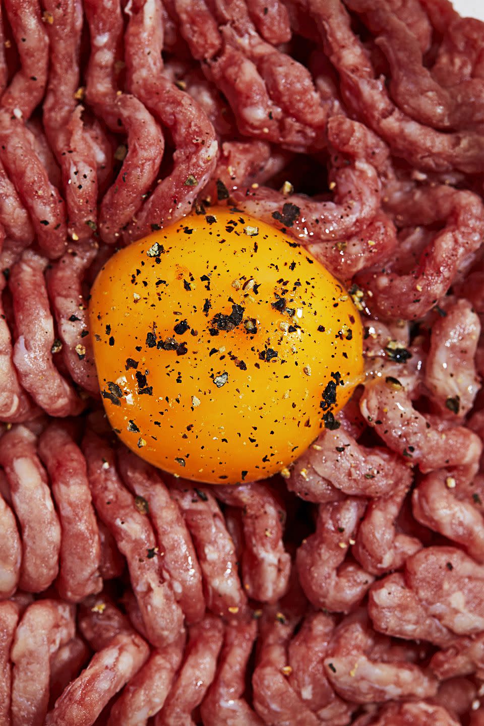 raw ground meat with egg yolk, salt and pepper