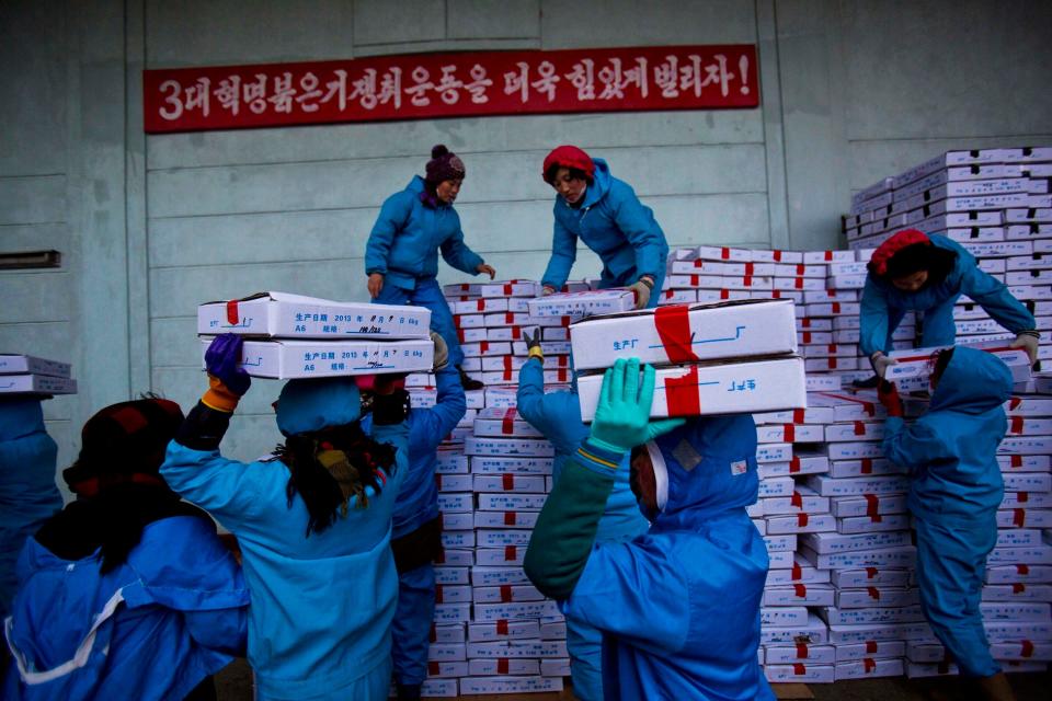 Workers carry boxes of seafood on Nov. 8, 2013, as they load a Chinese transport truck at the Suchae Bong Corp seafood factory in Rajin, North Korea, inside the Rason Special Economic Zone.