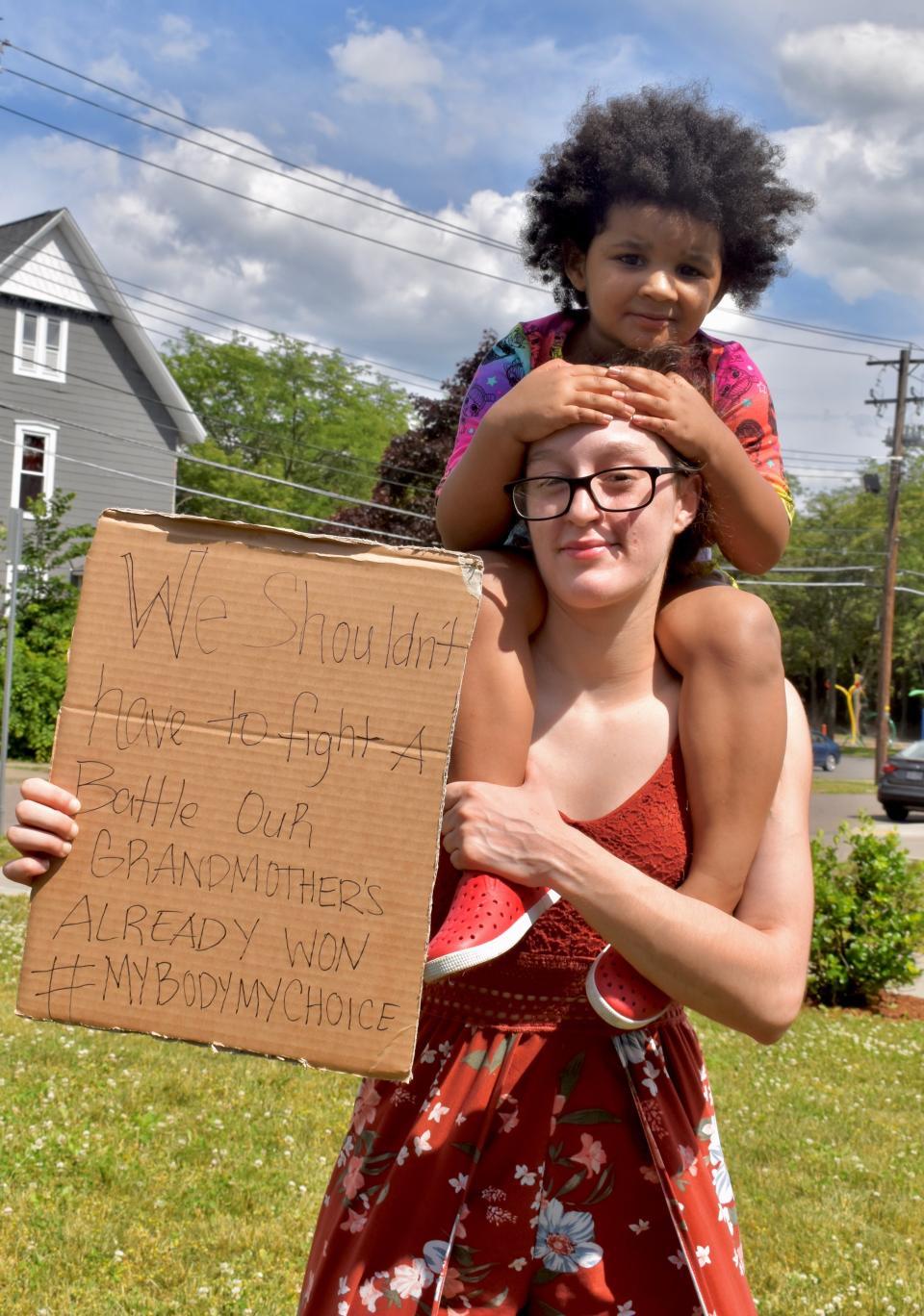 Binghamton resident Percephany Prosser and her 3-year-old daughter, Ariella, hold a sign in support of reproductive rights at a demonstration Monday, June 27, in front of the Family Planning of South Central New York clinic on Hawley Street in Binghamton.