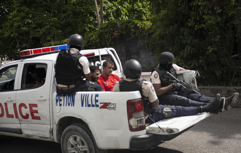 The police take two detainees to the police station of Petion Ville in Port-au-Prince, Haiti, Thursday, July 8, 2021. According to Police Chief Leon Charles, the two detained are suspects in the assassination of Haitian President Jovenel Moïse. (AP Photo/Joseph Odelyn)