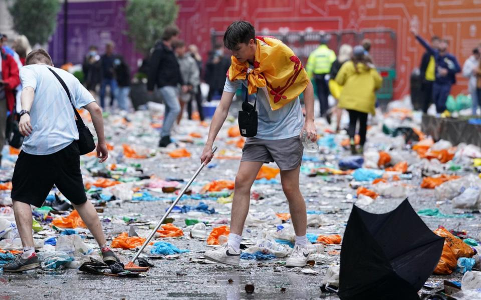 Scotland fans clean up litter in Leicester Square, London, ahead of the UEFA Euro 2020 Group D match between England and Scotland. Picture date: Friday June 18, 2021. PA Photo. See PA story SOCCER England. Photo credit should read: Kirsty O'Connor/PA Wire.  - Kirsty O'Connor/PA Wire