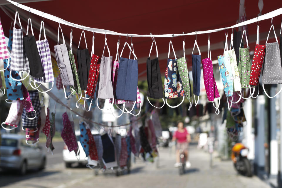 Protective masks in cotton sewn displayed for sale in front of a tailor shop in Berlin, Germany, Thursday, Aug. 13, 2020. In public transport, shops and public buildings at the German capital, it is essential to wear a face mask to protect against the coronavirus. (AP Photo/Markus Schreiber)