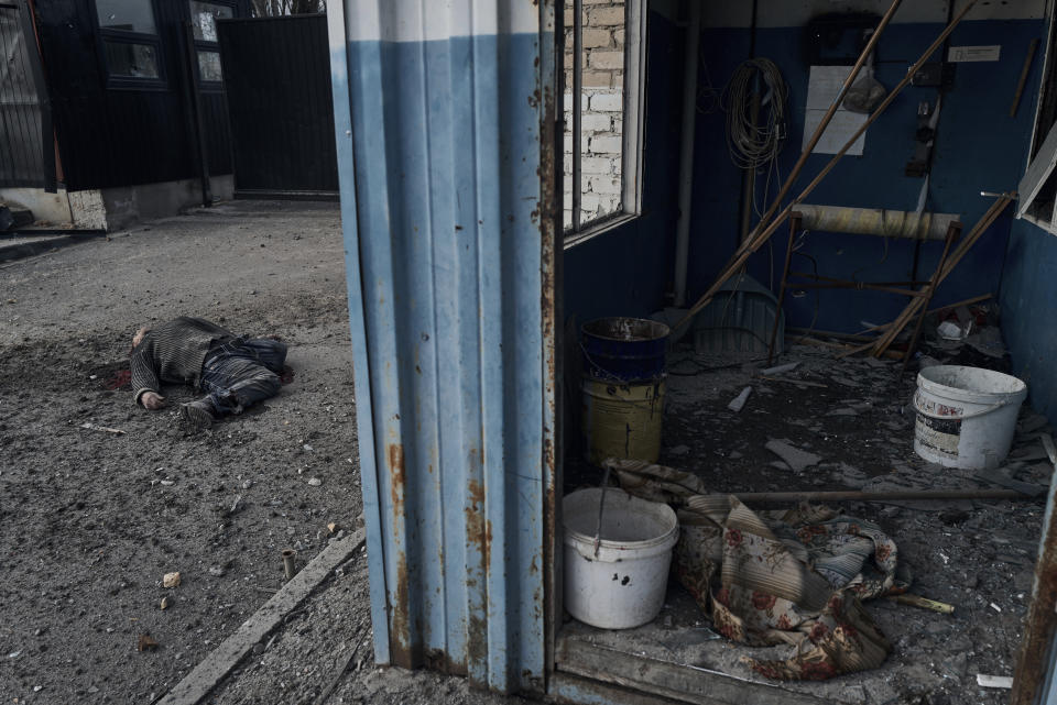 The body of a local citizen who was killed in Russian shelling, lies on the ground in Kherson, Ukraine, Friday, Feb. 3, 2023. (AP Photo/LIBKOS)