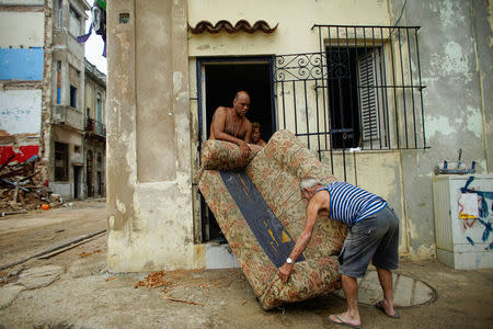 A family carries a sofa out to dry outside their home after Hurricane Irma caused flooding and a blackout, in Havana, Cuba September 11, 2017. REUTERS/Alexandre Meneghini