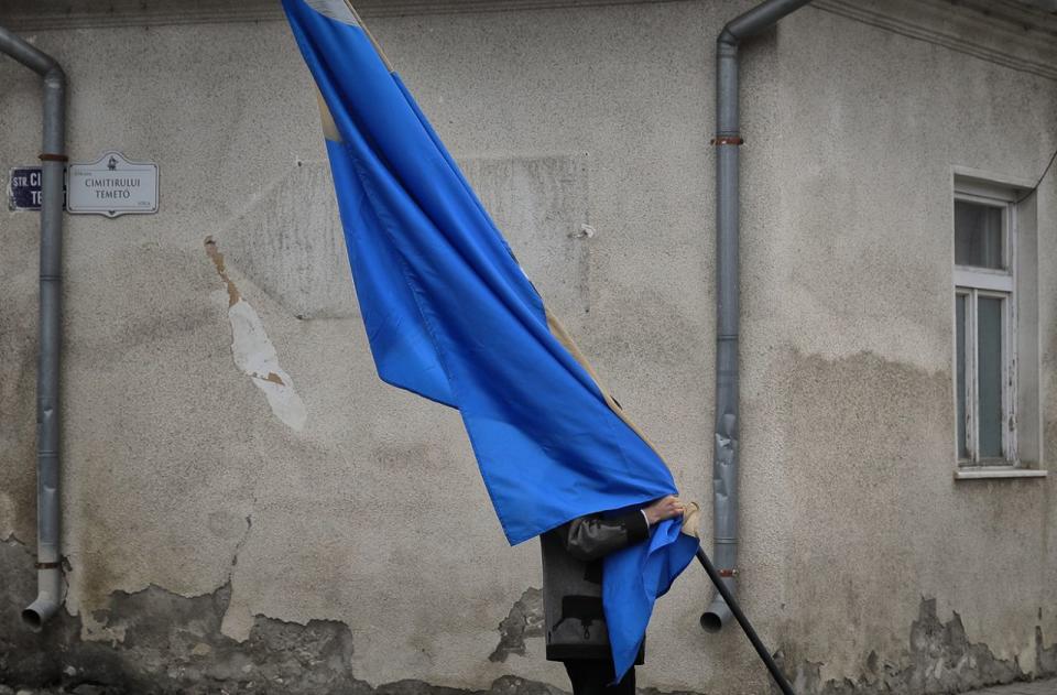 <p>Ein Mann trägt im rumänischen Târgu Secuiesc eine Flagge der Szekler. Die Gruppe ethnischer Ungarn ist im östlichen Teil Transsilvaniens beheimatet. (Bild: Vadim Ghirda/AP) </p>