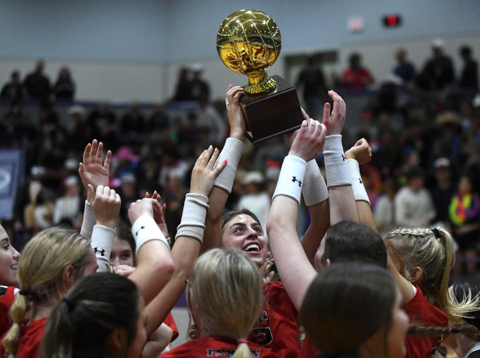 Lubbock-Cooper celebrates with its trophy after beating Amarillo High in a regional quarterfinal match Tuesday, Nov. 8, 2022, at Kenneth Cleveland Gymnasium in Dimmitt.