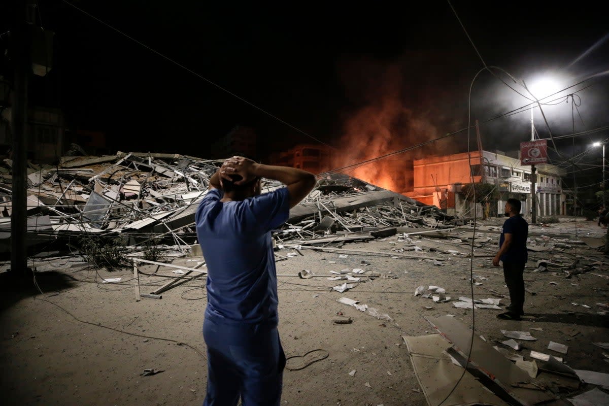 Palestinians look at the aftermath of an Israeli air strike on Gaza City (EPA)