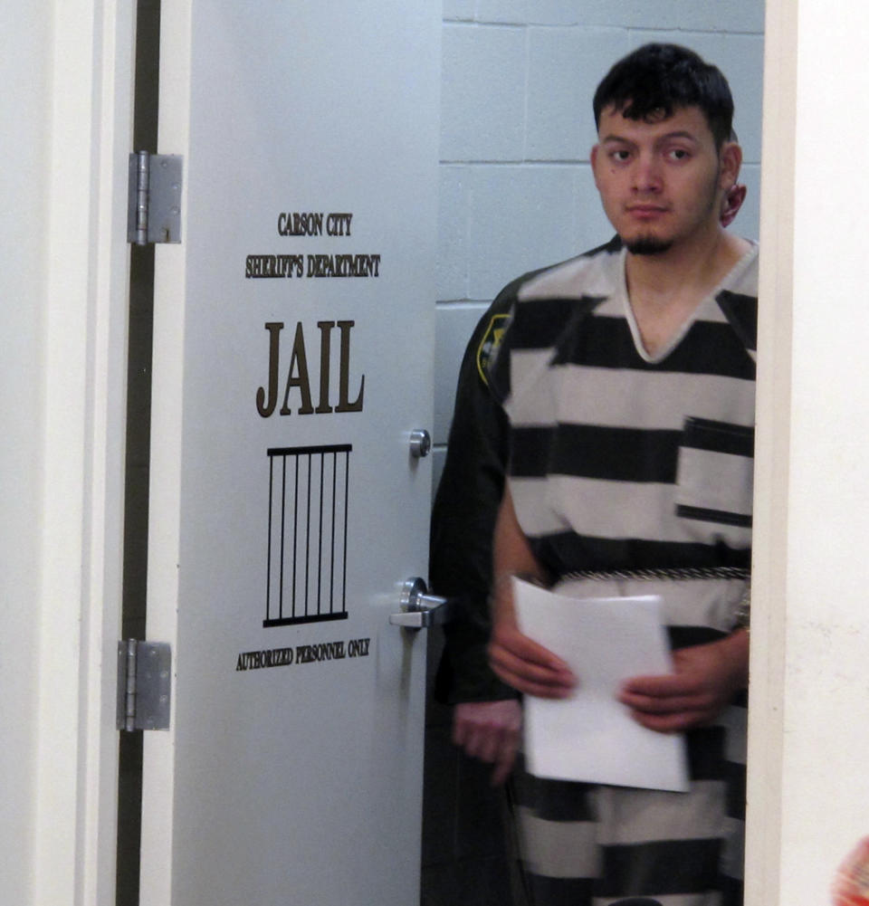 Wilber Ernesto Martinez-Guzman, 19, of El Salvador, is escorted into the courtroom for his initial appearance in Carson City Justice Court, Thursday, Jan. 24, 2019, in Carson City, Nev. Martinez-Guzman was arraigned on 36 felonies including two dozen weapon charges. He's a suspect in a series of four homicides earlier this month in Reno and south of Carson City in rural Gardnerville. Prosecutors say additional charges are pending. (AP Photo/Scott Sonner).