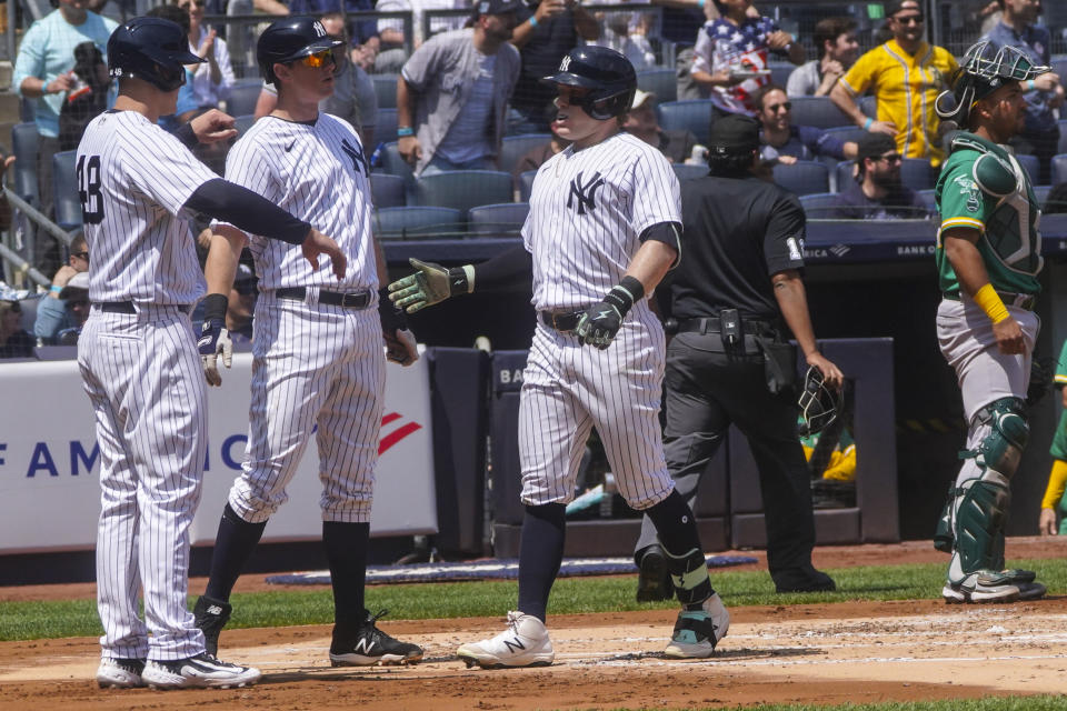 New York Yankees' Harrison Bader, center, reaches for a handshake at home plate after hitting a three-run home run in the first inning of a baseball game against Oakland Athletics, Wednesday, May 10, 2023, in New York. (AP Photo/Bebeto Matthews)
