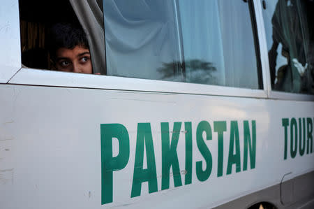 FILE PHOTO: A Pakistani boy travelling from Delhi to Lahore looks out the window of a bus as it leaves the Wagah-Attari border crossing, Pakistan, March 15, 2019. REUTERS/Alasdair Pal