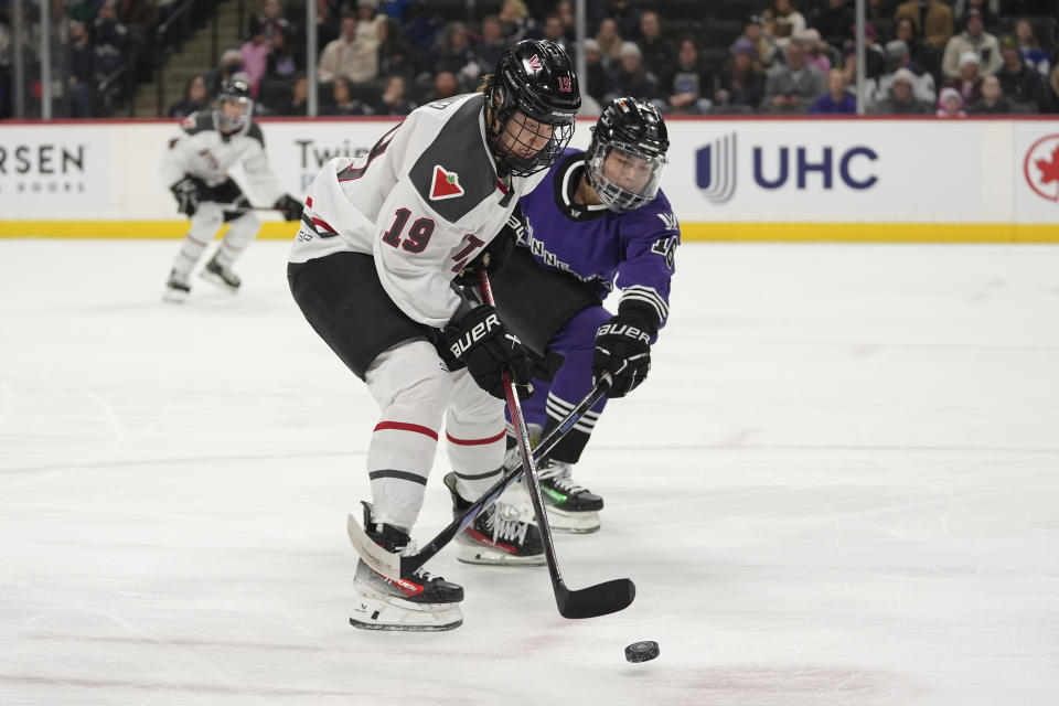 Ottawa forward Brianne Jenner (19) and Minnesota defender Sophie Jaques vie or the puck during the first period of a PWHL hockey game Wednesday, Feb. 14, 2024, in St. Paul, Minn. (AP Photo/Abbie Parr)