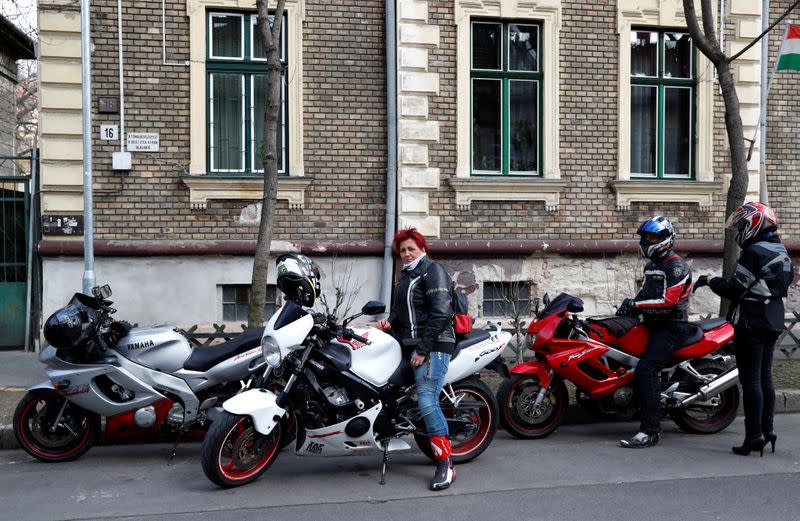 Morucz, a member of the 'Easy Riders', a Hungarian bikers group, sits on her bike after she recovered the belongings of a domestic violence victim in Budapest