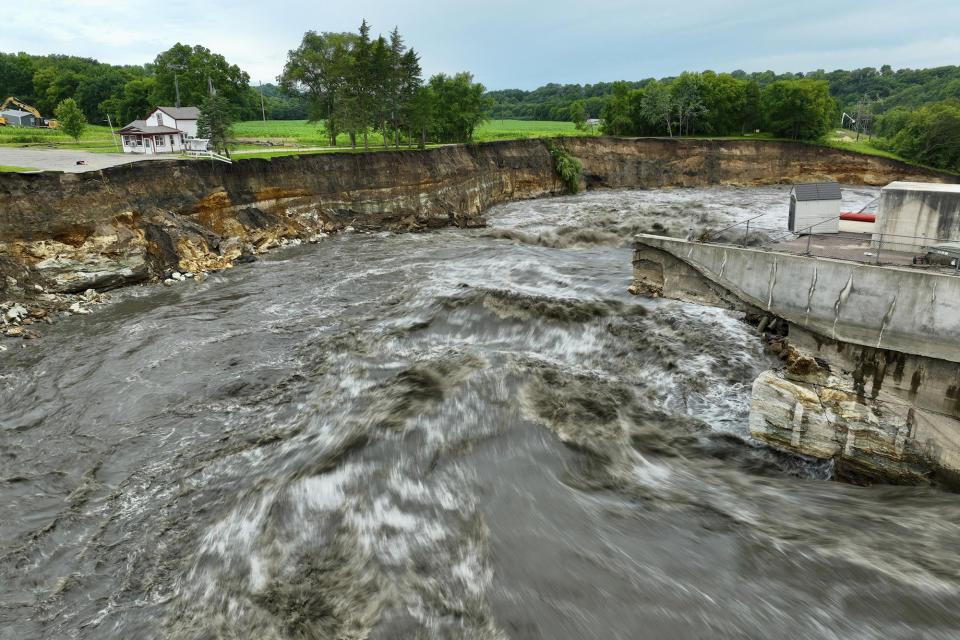Floodwater continues to carve a channel around the Rapidan Dam, Thursday, June 27, 2024, near Mankato, Minn. Water breached the earthen abutment early Monday morning and rapidly eroded the west bank of the Blue Earth River. (AP Photo/Mark Vancleave)