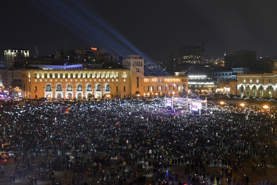 Supporters of Armenian Prime Minister Nikol Pashinyan hold up phones during a rally in the center of Yerevan, Armenia, Monday, March 1, 2021. Amid escalating political tensions in Armenia, supporters of the country's embattled prime minister and the opposition are staging massive rival rallies in the capital of Yerevan. Prime Minister Nikol Pashinyan has faced opposition demands to resign since he signed a peace deal in November that ended six weeks of intense fighting with Azerbaijan over the Nagorno-Karabakh region. (Karo Sahakyan/PAN Photo via AP)