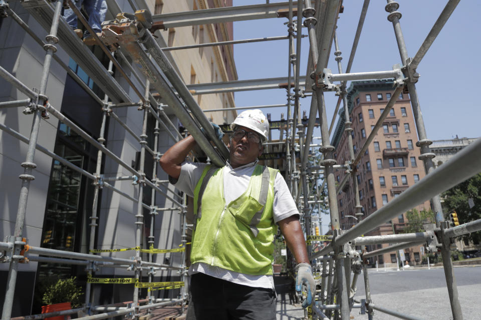 A construction worker carries bars while helping build a scaffolding on the side of a hotel in the Mount Vernon section of Baltimore. In the latest rhetorical shot at lawmakers of color, President Donald Trump over the weekend vilified Rep. Elijah Cummings majority-black Baltimore district as a "disgusting, rat and rodent infested mess" where "no human being would want to live." (AP Photo/Julio Cortez)