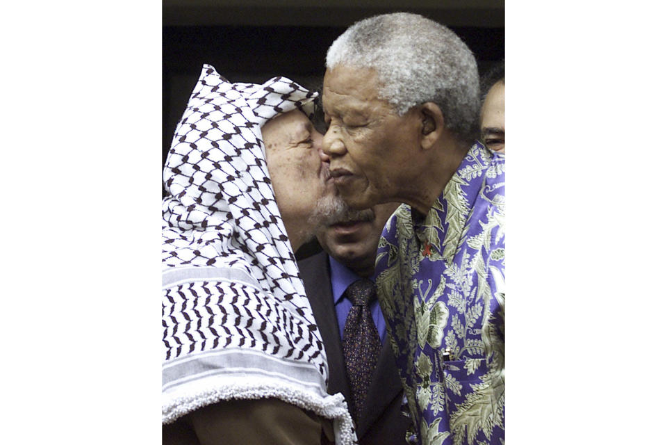 FILE — Late Palestinian leader Yasser Arafat, left, embraces the late former South Africa President Nelson Mandela, right, at a meeting in Johannesburg Thursday May 3, 2001. South Africa's long-held support for the Palestinian people can be traced back to the time of Mandela and Arafat with the two leaders believing that the struggle for freedom by Blacks in apartheid South Africa and Palestinians in Gaza and the West Bank were the same. (AP Photo/Denis Farrell, File)