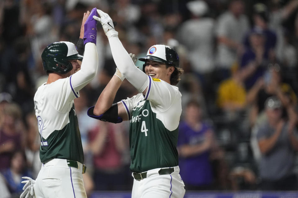 Colorado Rockies' Nolan Jones, left, congratulates Michael Toglia, who hit a three-run home run off Pittsburgh Pirates relief pitcher Dennis Santana during the eighth inning of a baseball game Saturday, June 15, 2024, in Denver. (AP Photo/David Zalubowski)