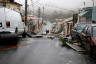 People walk on the street next to debris after the area was hit by Hurricane Maria in Guayama, Puerto Rico September 20, 2017. REUTERS/Carlos Garcia Rawlins