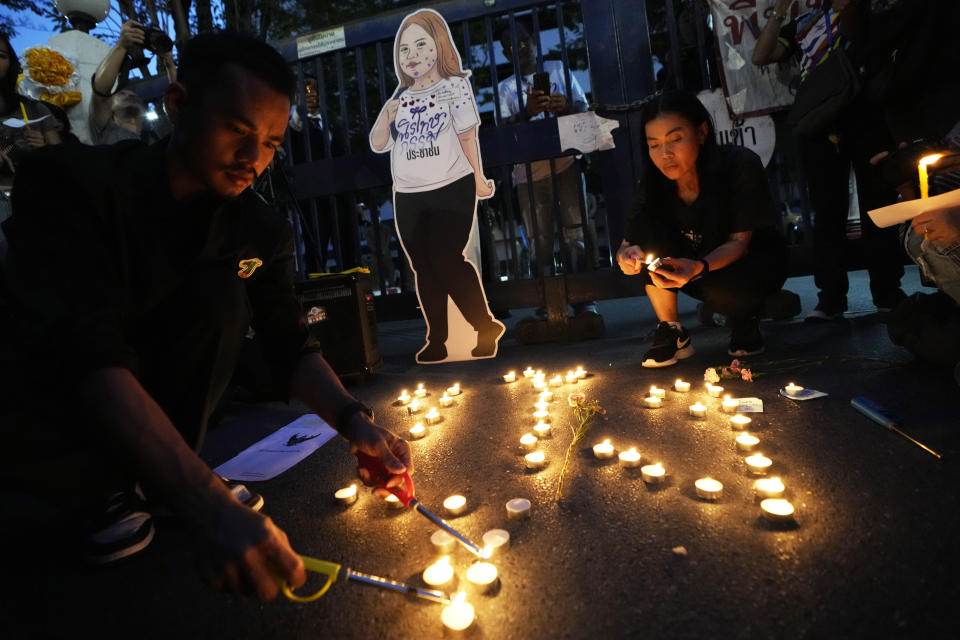 Thai activists hold candles during a vigil for Netiporn Sanesangkhom, a member of the activist group Thaluwang, known for their bold and aggressive campaigns demanding reform of the monarchy and abolition of the law that makes it illegal to defame members of the royal family, outside of Criminal court in Bangkok, Thailand, Tuesday, May 14, 2024. Netiporn who went on a hunger strike after being jailed for her involvement in protests calling for reform of the country's monarchy system died Tuesday in a prison hospital, officials said. (AP Photo/Sakchai Lalit)