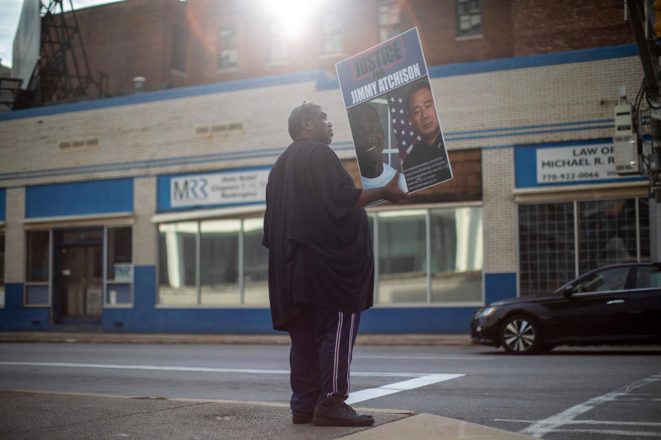 Jimmy Hill holds a poster with a photo of his son. (Alyssa Pointer for NBC News)