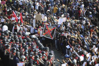 Protesters flashing three-fingered salutes and holding an image with an X mark on a photo of Myanmar Commander-in-Chief Senior Gen. Min Aung Hlaing face rows of riot police in Naypyitaw, Myanmar on Monday, Feb. 8, 2021, after Feb. 1 coup. In the month since, the mass protests occurring each day are a sharp reminder of the long and bloody struggle for democracy in a country where the military ruled directly for more than five decades. (AP Photo)