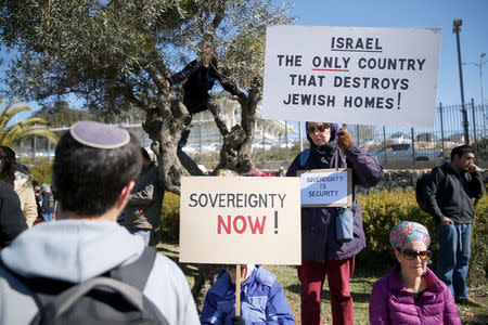 Protesters hold placards during a demonstration against the expected eviction of the Israeli settler outpost of Amona in the occupied West Bank, in Jerusalem January 30, 2017. REUTERS/Baz Ratner