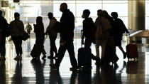 FILE - In this Nov. 25, 2020, file photo, air travelers line up to go through a a security checkpoint at Salt Lake City International Airport in Salt Lake City. Data from roadways and airports shows millions could not resist the urge to gather on Thanksgiving, even during a pandemic. (AP Photo/Rick Bowmer, File)