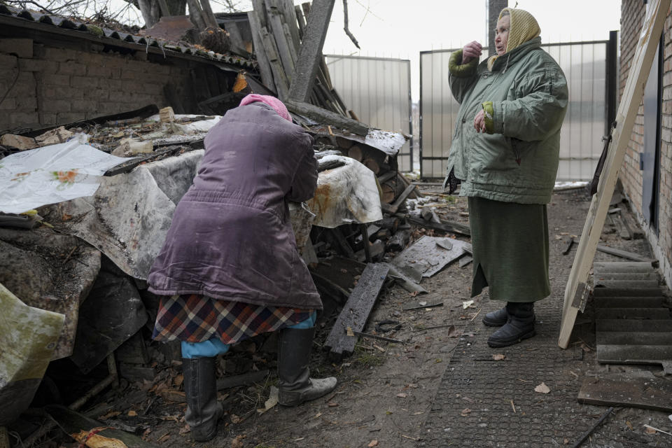 Women are overwhelmed by emotion in the backyard of a house damaged by a Russian airstrike, according to locals, in Gorenka, outside the capital Kyiv, Ukraine, Wednesday, March 2, 2022. Russia renewed its assault on Ukraine's second-largest city in a pounding that lit up the skyline with balls of fire over populated areas, even as both sides said they were ready to resume talks aimed at stopping the new devastating war in Europe.(AP Photo/Vadim Ghirda)