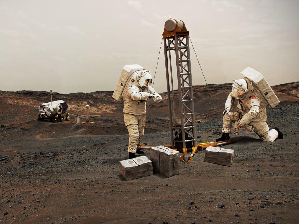 illustration shows astronauts using equipment on mars