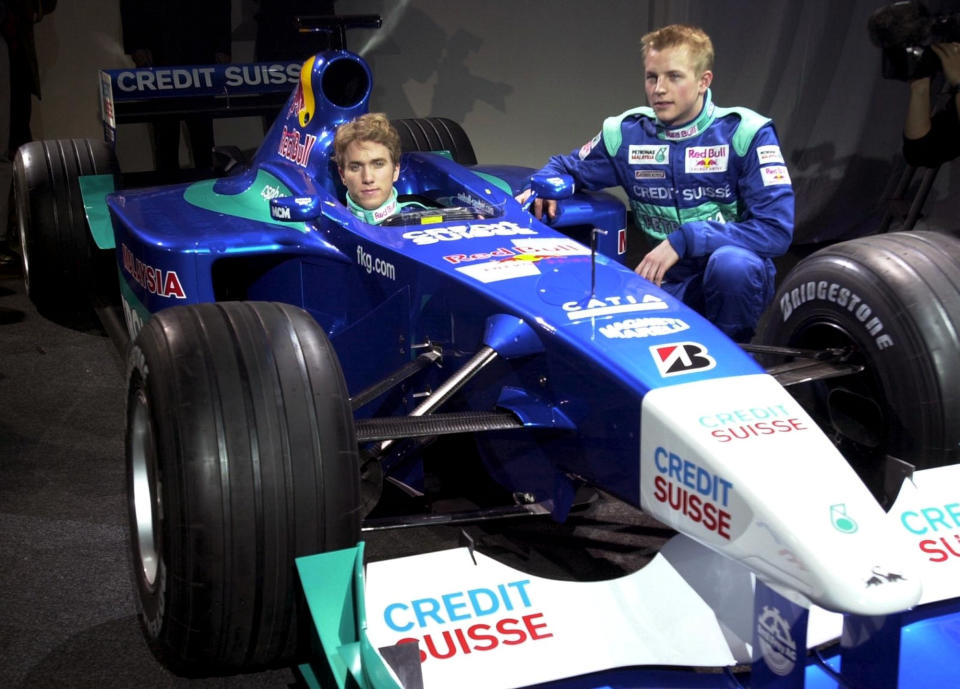 German driver Nick Heidfeld, left, sits in the cockpit of the new Red Bull-Sauber-Petronas C20 Formula One racing car, while his Finnish colleague Kimi Raikkonen, right, looks on during the car's presentation in Hinwil, Switzerland, Wednesday, Jan. 24, 2001. The Swiss racing team unveiled its blue and white racing car, which is powered by a Ferrari engine and  will have its first start during the season opener March 4 in Australia. (AP Photo/Steffen Schmidt, Keystone)