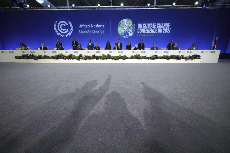 FILE - Britain's Chancellor Rishi Sunak, center right, and Prime Minister Boris Johnson's Finance Adviser for COP26, Mark Carney, center left, pose for a photo in front of photographer's shadows with world finance ministers, during the COP26 summit, at the Scottish Event Campus (SEC) in Glasgow, Scotland, Nov. 3, 2021. (Christopher Furlong/Pool Photo via AP, File)