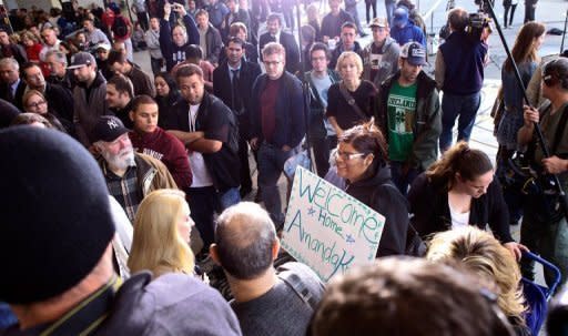 An Amanda Knox supporter (C) holds a sign before a press conference in Seattle, Washington. A tearful Knox paid tribute to her supporters as she arrived home, after being acquitted of murder and sexual assault and ending a four-year ordeal behind bars in Italy