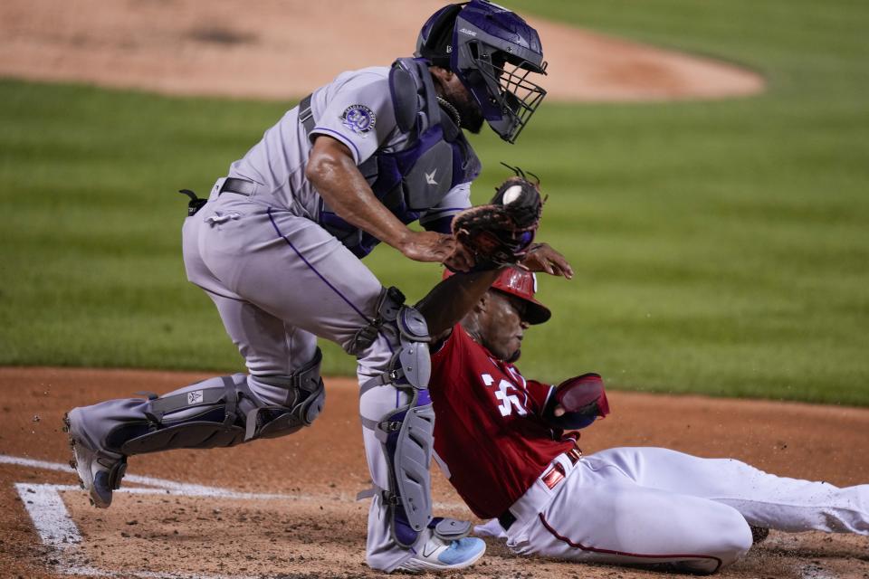 Washington Nationals' Stone Garrett is out at home on the tag by Colorado Rockies catcher Elias Diaz during the second inning of a baseball game at Nationals Park, Tuesday, July 25, 2023, in Washington. (AP Photo/Alex Brandon)