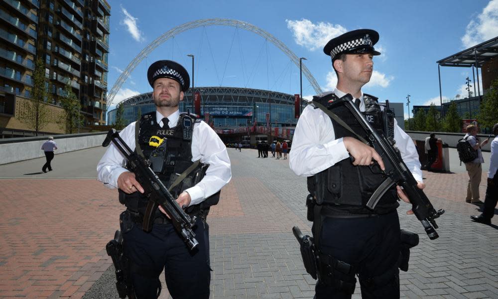  Armed police officers patrol outside Wembley Stadium ahead of the FA Cup final between Arsenal and Chelsea on Saturday