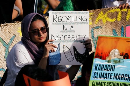 A participant holds a sign as she takes part in the Global Climate Strike with others in Karachi,