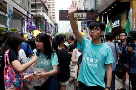 Pro-democracy activist Joshua Wong waves to pro-democracy protesters during a march marking the 20th anniversary of Hong Kong's handover to Chinese sovereignty from British rule, in Hong Kong, China July 1, 2017. REUTERS/Tyrone Siu