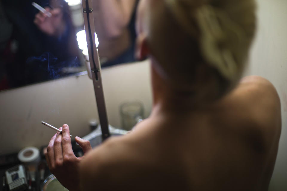 In this photo taken Saturday, Feb. 8, 2014, Lisa, who would only give his stage name, smokes a cigarette while getting ready backstage before a performance at the Mayak cabaret, the most reputable gay club in Sochi, Russia, host to 2014 Winter Olympics. Russia adopted a law last year, prohibiting vaguely defined propaganda of non-traditional sexual relations and pedophilia. The legislation makes it illegal to disseminate information to children even if it merely shows that gay people are just like everybody else. At Mayak, packed on Saturday night, gay men and women steered away from discussing the law, preferring to enjoy life, closeted as it is. About a hundred people were chatting at the bar, sitting in armchairs or dancing. Couples were sharing kisses. Everyone was waiting for the club's specialty: a drag show. At 1.30 a.m. on Sunday, the music stopped and the show began. (AP Photo/David Goldman)