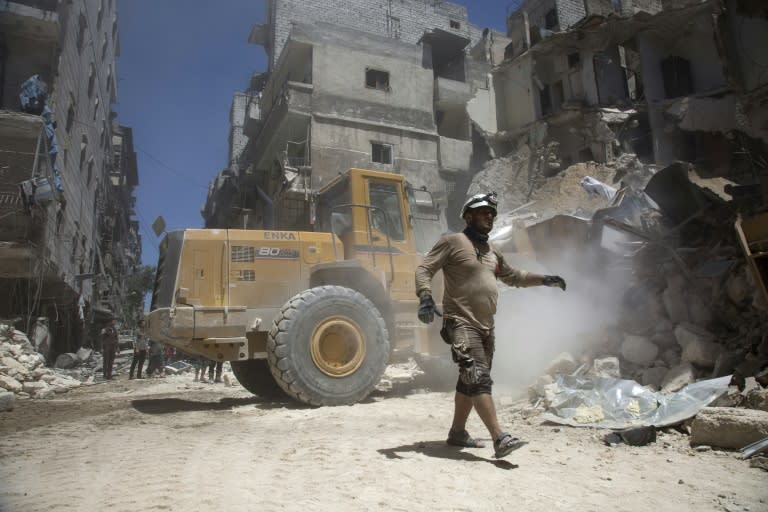 Syrian rescue workers clear rubble in the war-shattered city of Aleppo on July 26, 2016