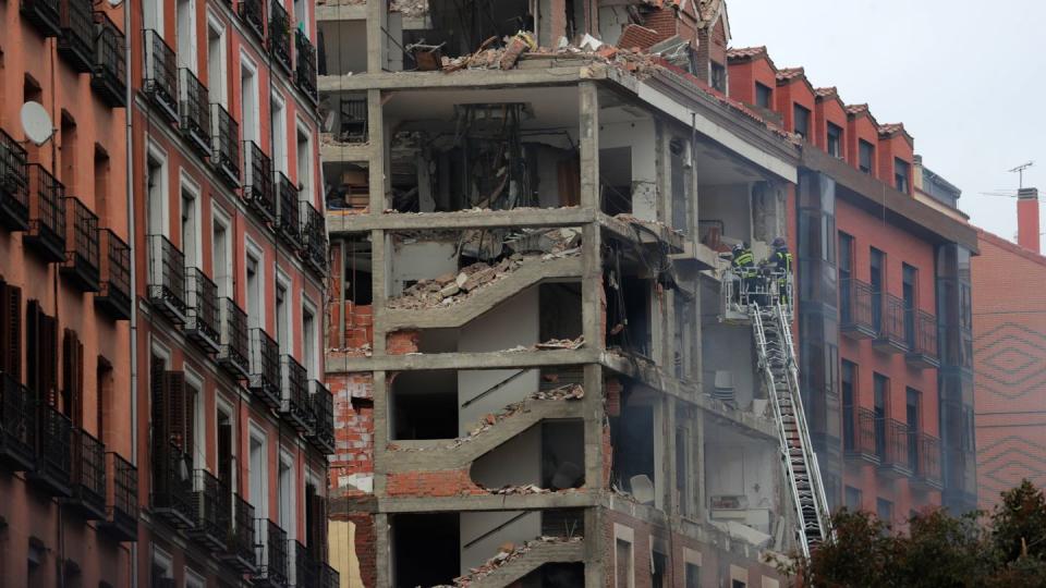 Feuerwehrleute arbeiten nach der schweren Explosion an dem beschädigten Gebäude in Madrids Toledo Straße.