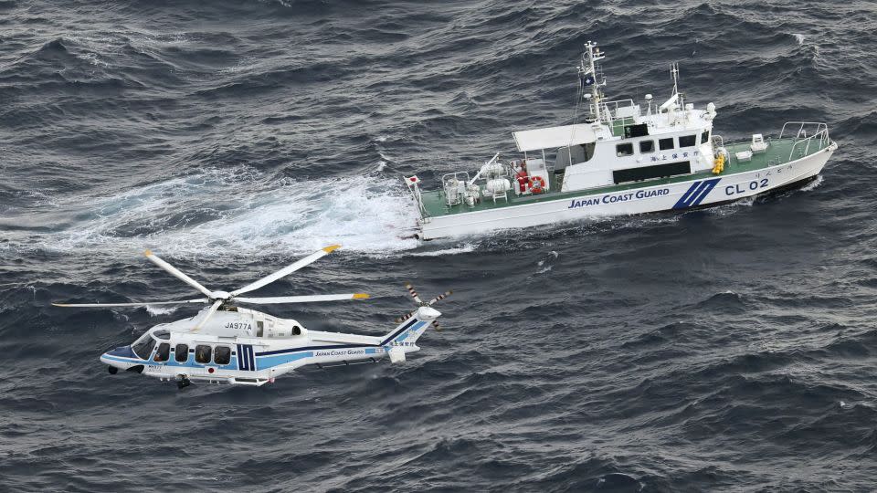 A Japan Coast Guard vessel and a helicopter conduct a search and rescue operation at the site where a US military aircraft V-22 Osprey crashed into the sea off Yakushima Island, Kagoshima prefecture, Japan November 30, 2023. - Kyodo/Reuters