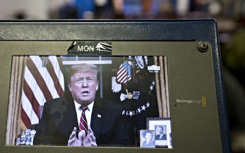 A television monitor in the White House press briefing room broadcasts U.S. President Donald Trump's address on border security  - Credit: Bloomberg