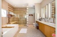 <p>The master bathroom boasts an ultra-modern shower and a soaker tub. (Zillow) </p>