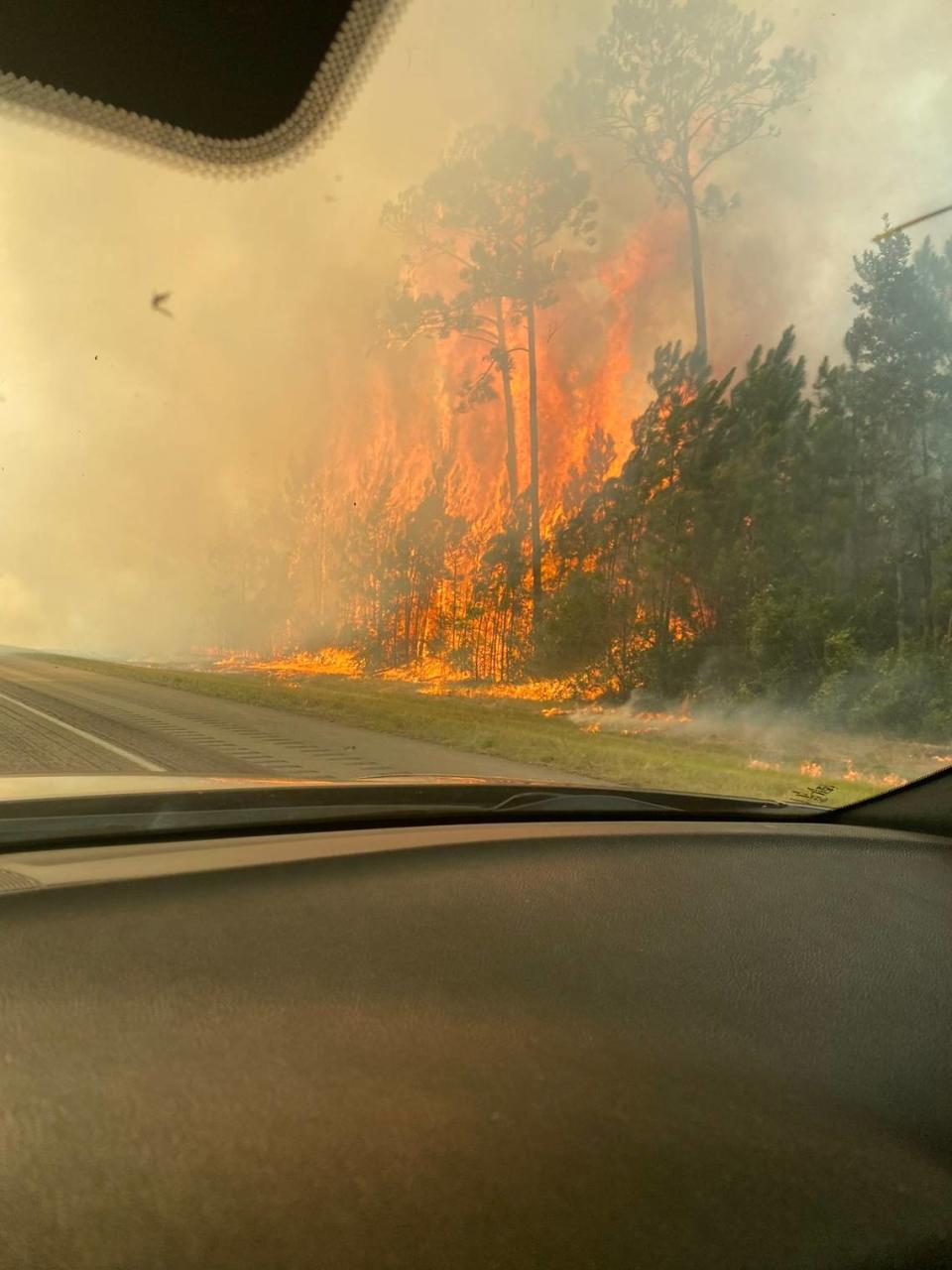 A large grass fire burns at the 2 mile-marker on I-10 in Hancock County on Friday, Aug. 10, 2023. The Interstate has been shut down for safety reasons. Mississippi Highway Patrol